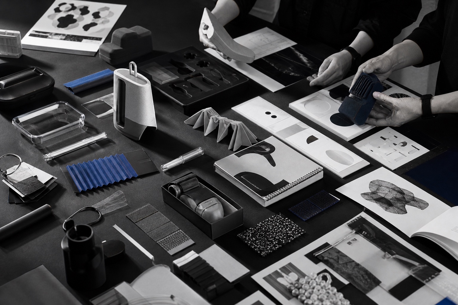 Industrial and graphic designers comparing product prototypes, materials, packaging, and publication studies
